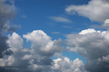 Bright Blue Sky with White Fluffy Clouds on a Sunny Day - Nature Background and Weather Concept