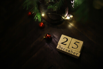 Christmas Tree Decorations with December 25th Date Block on Dark Wooden Floor