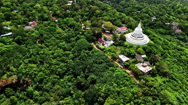 Drone aerial landscape of Japanese Peace Pagoda Buddhism temple tower monastery building Rumassala overlooking headland coastline forest Unawatuna Galle Sri Lanka Asia religion tourism travel