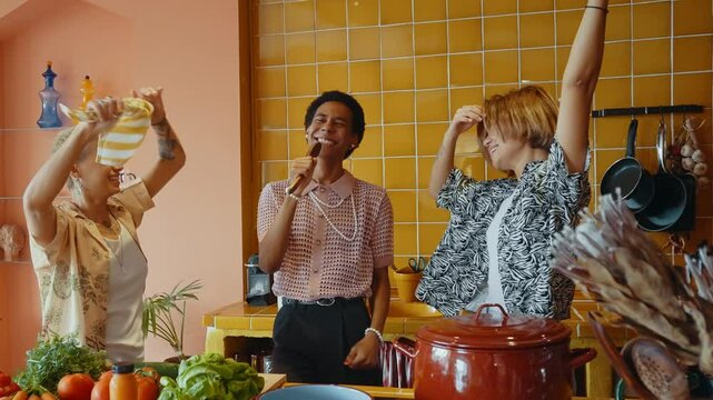 Group of friends bonding at home, LGBTQ and diversity concepts - Homosexual couple and fluid gender non binary young man with cross dressing clothing style having fun in the apartment, LGBT people