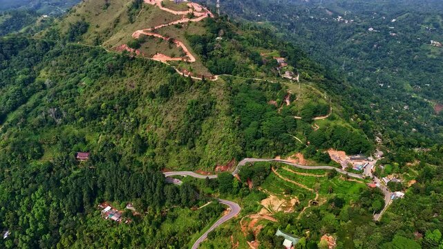 Drone aerial landscape of winding roads through mountain peak summit in village town with trees vegetation forest nature Gampola Kandy District Sri Lanka travel tourism vacation hiking