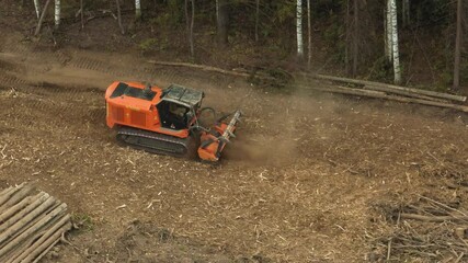 A mulcher shred organic material, leaves, branches, grass, or other plant debris, into smaller pieces. Construction of a road through the forest. Cutting and clearing of forest for road construction.