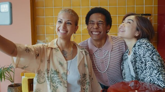 Group of friends bonding at home, LGBTQ and diversity concepts - Homosexual couple and fluid gender non binary young man with cross dressing clothing style having fun in the apartment, LGBT people
