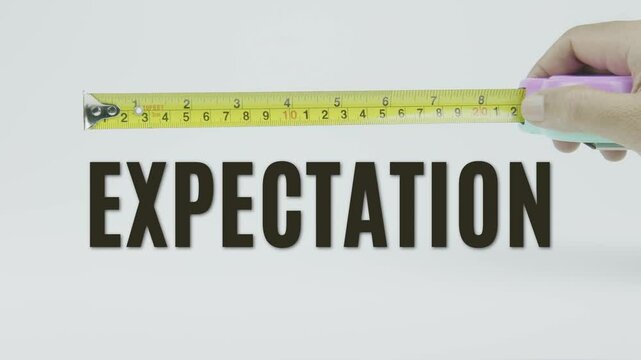 "Expectation" text with a tape measure on a white background, symbolizing precision in standards, measurement, and goal setting
