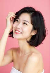 Fototapeta premium ピンクの背景に短いスタイリングされた髪に触れる穏やかな日本人女性：輝きのある完璧な肌に焦点を当てて、美しさ、ウェルネス、そして美学を強調するポートレート。美容とパーソナルケアブランドに最適。