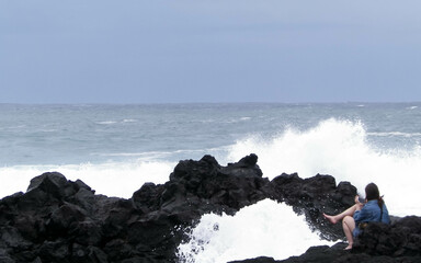 Woman relaxing on Sao Miguel Island coast.