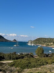 Obraz premium Scenic coastal view featuring sailboats in a tranquil bay on a sunny day