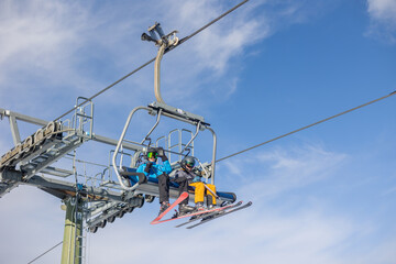 Children and adults, happy family in winter clothing at ski vacation, skiing, winter