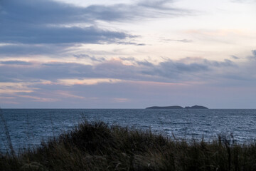 Lively sky over St Tudwal islands off Abersoch Wales from Pwllheli Beach