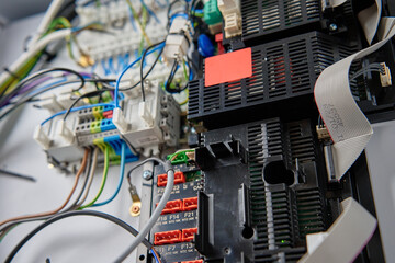 Close-up view of wiring system and circuit board inside electrical control panel. Electrical...