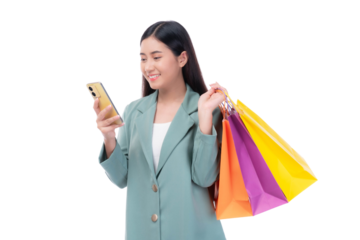 Beautiful Asian woman in a green blazer holding colorful shopping bags and using a smartphone, smiling with excitement while shopping online, isolated on a transparent background