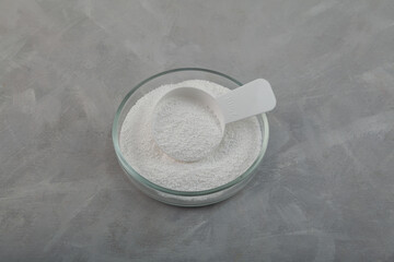 Sodium percarbonate powder or sodium carbonate peroxide in measuring spoon and Petri dish. It is abbreviated as SPC. Chemical substance used in eco-friendly bleaches with active oxygen