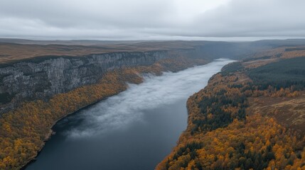 Breathtaking Aerial View of Serene River and Cliffside in Autumn Landscape with Vibrant Orange Foliage and Overcast Sky Captured at Sunrise - Perfect for Nature Lovers