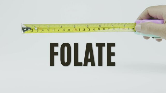 "Folate" text with a tape measure on a white background, symbolizing precision, accuracy, and measurement in a clean, minimal style