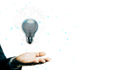 Businessman’s hand holding a glowing lightbulb with digital elements on a white background, representing creativity, ideas, and innovation