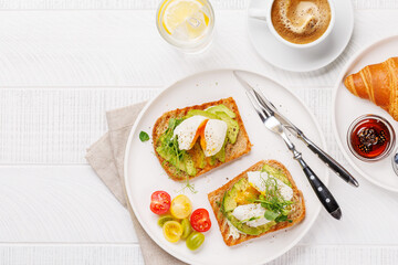 Breakfast with delicious avocado toasts and crispy croissant