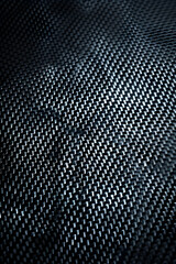 Close-up view of textured black fabric with intricate weave pattern suitable for fashion design