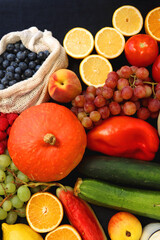 Various healthy fruits, vegetables and cereals on dark background. Top view.