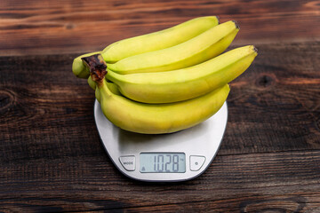 bunch bananas on the scales on wooden table