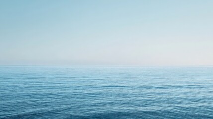 Obraz premium The peaceful blue sea, with light waves and a clear horizon, leaving plenty of empty space for design or text.
