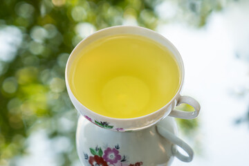 Cup of green tea on table green blur background