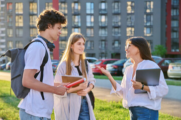 Group of college students talking with female teacher coach mentor, outdoor