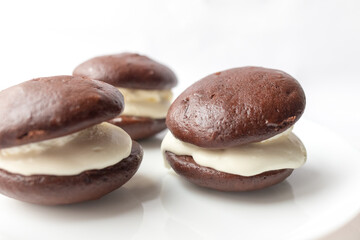 Chocolate cookies whoopie pie with cream on the white background. Black-and-white, Bob, BFO. Ready to eat. Homemade baking