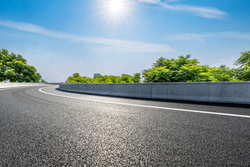 A curving road under the bright sun and blue sky