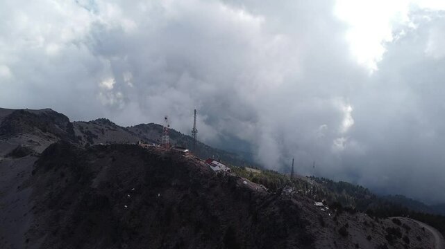 Drone flying to the communication antennas on the cliff on the nevado de colima national park