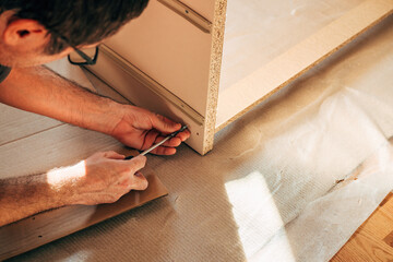 Man assembling furniture at home for a DIY project