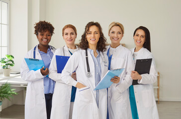 Happy female doctor group, clinic diverse team in medical professional uniforms in clinic office...