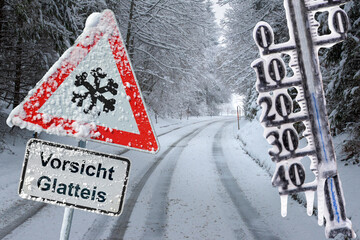 Ein Verkehrsschild warnt vor Glatteis auf den Straßen mit Minustemperatur auf dem Thermometer -...