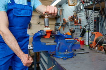 Cropped shot of craftsman using antique bench vise in repair shop