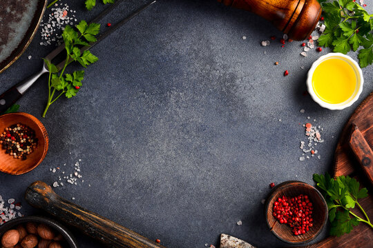 Black stone cooking background. Spices and vegetables. Top view. Free space for your text.