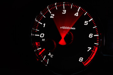 Car dashboard. Red arrow moving on tachometer and engine cooling temperature close-up