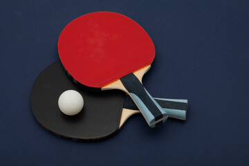 Professional Black and Red Table Tennis Paddles with White Ball on Navy Background | Sports Equipment Photography