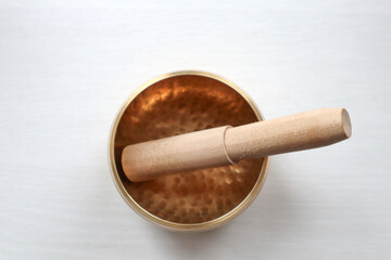 Singing bowl on the table. Soud healing. Tibetan bowl on the white background top view.