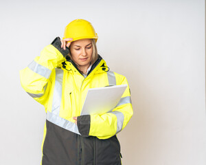 a girl in a yellow special protective jacket and a protective yellow helmet with papers in her hands. High quality photo