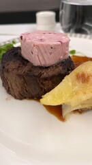 Gourmet Steak with Berry Butter and Gratin: Juicy grilled steak topped with berry-infused butter, served with rich potato gratin and sauce on a fine dining plate.