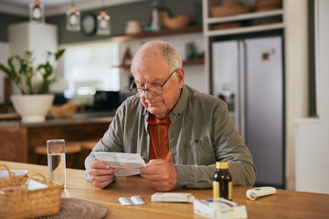 Old man wearing specs and reading medicine leaflet