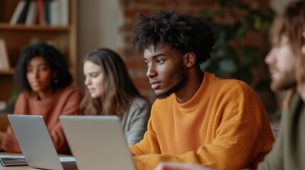 Students engage in a focused study session using laptops in a warm, inviting workspace filled with plants