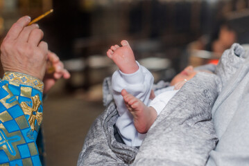 Baptism ceremony taking place in a church with a priest and a baby being blessed