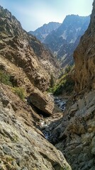 Obraz premium Serene Mountain Landscape with Rocky Terrain and Flowing River
