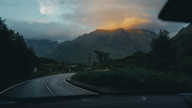 driving through mountains at sunset