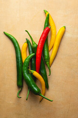 Multi-colored hot peppers on a warm orange background. Spices and spicy flavors from the cuisine of...