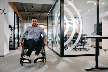 In a large modern corporation, a determined businessman in a wheelchair navigates through a...