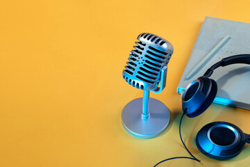 Retro microphone close-up with blue neon lights on yellow background. Backdrop for a podcast recording studio. Workspace, copy space
