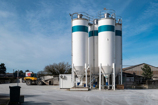 F&aacute;brica com alguns silos de armazenamento de cimento para a produ&ccedil;&atilde;o de concreto em meio a um dia ensolarado