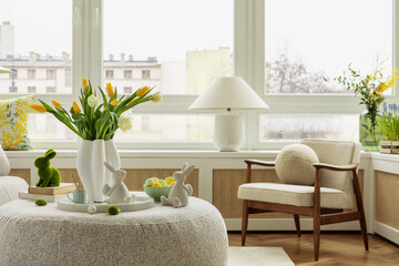Interior design of spring living room with design sofa, furniture, vase with tulips, easter...