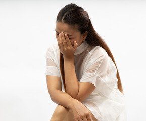 Emotional Moment Captured With a Woman Covering Her Face in a Minimalist Setting During Daylight